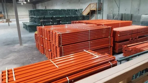 A warehouse filled with lots of orange steel poles.