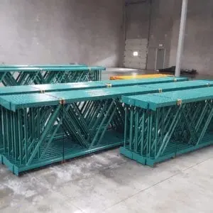 A group of green metal tables in a room.